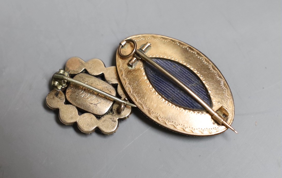 A Victorian yellow metal, garnet and seed pearl set mourning brooch, with plaited hair below a glazed panel, 24mm and a similar navette shaped yellow metal, enamel and seed pearl pendant brooch.